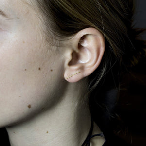 yellow gold version of the double line studs on a model